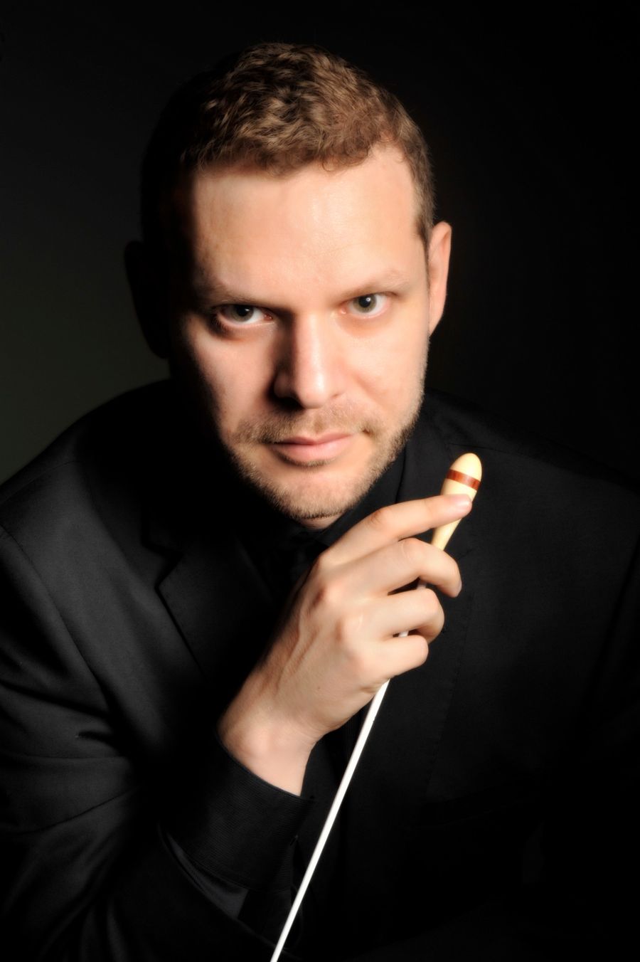 Portrait of Andrés Soto, orchestrator and conductor, holding a baton